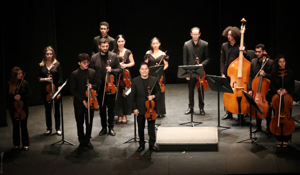 Músicos en escenario cultural presentándose ante el publico